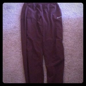 Nike dry fit maroon pants with gray Nike logo.
